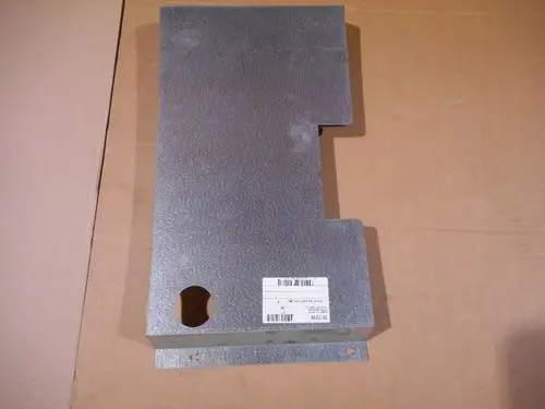 Unterseite eines metallischen Wandteils mit einer Aussparung und einem Etikett. Produkt stammt von Remeha, Vorlage auf einem braunen Karton.
